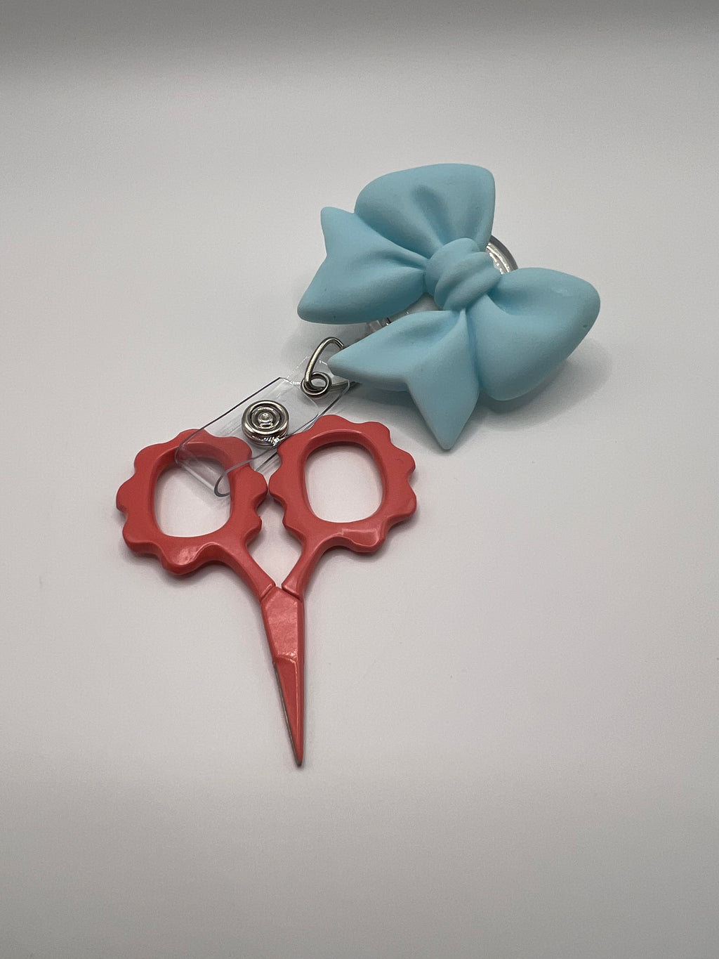 Baby blue bow badge reel for badge or scissors.  Scissors not included