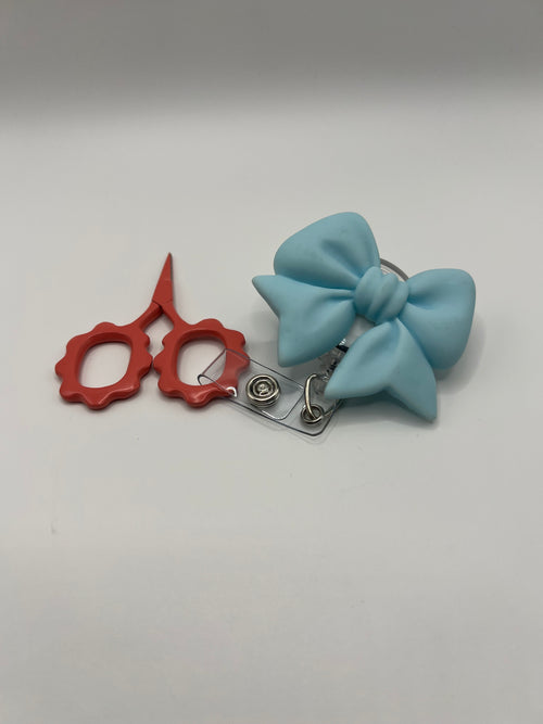 Baby blue bow badge reel for badge or scissors.  Scissors not included