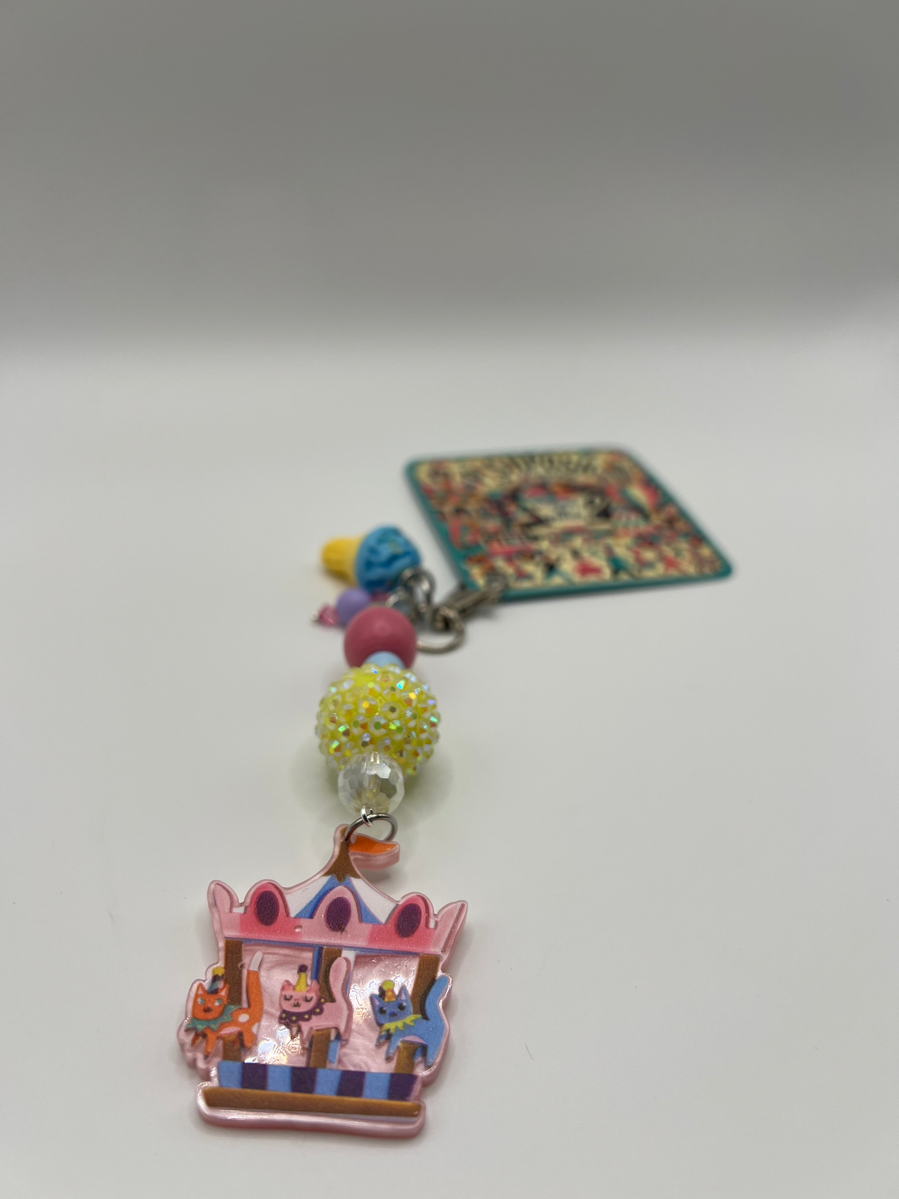 Cats on a carousel with blue ice cream charm