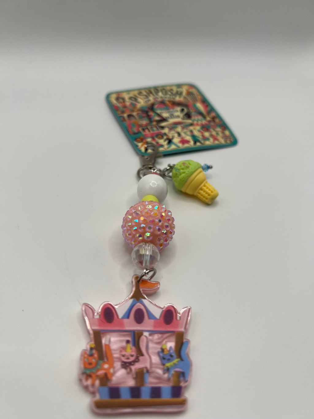 Cats on a carousel with green ice cream charm
