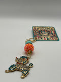 Multi-colored poodle with orange bead charm