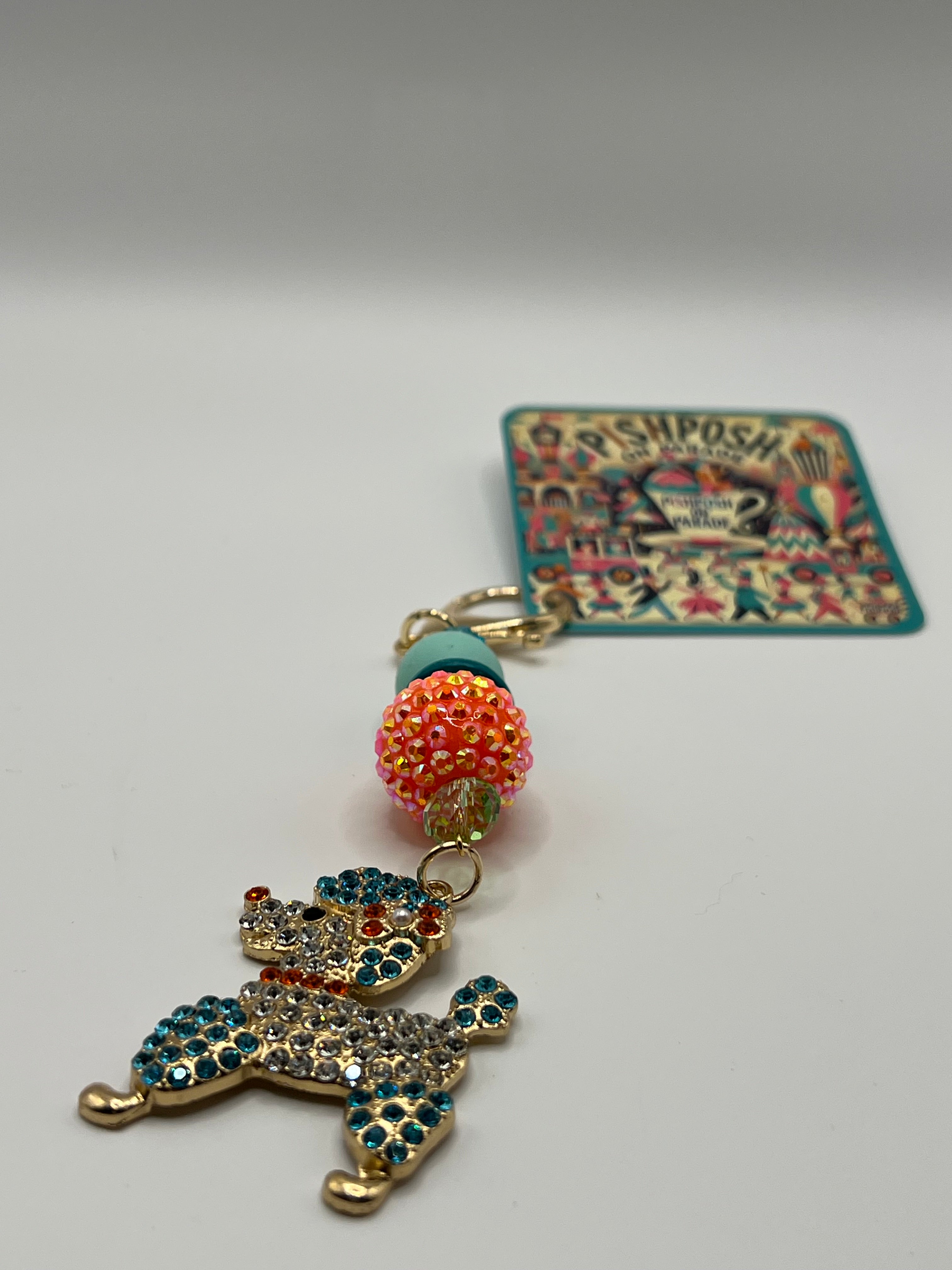Multi-colored poodle with orange bead charm