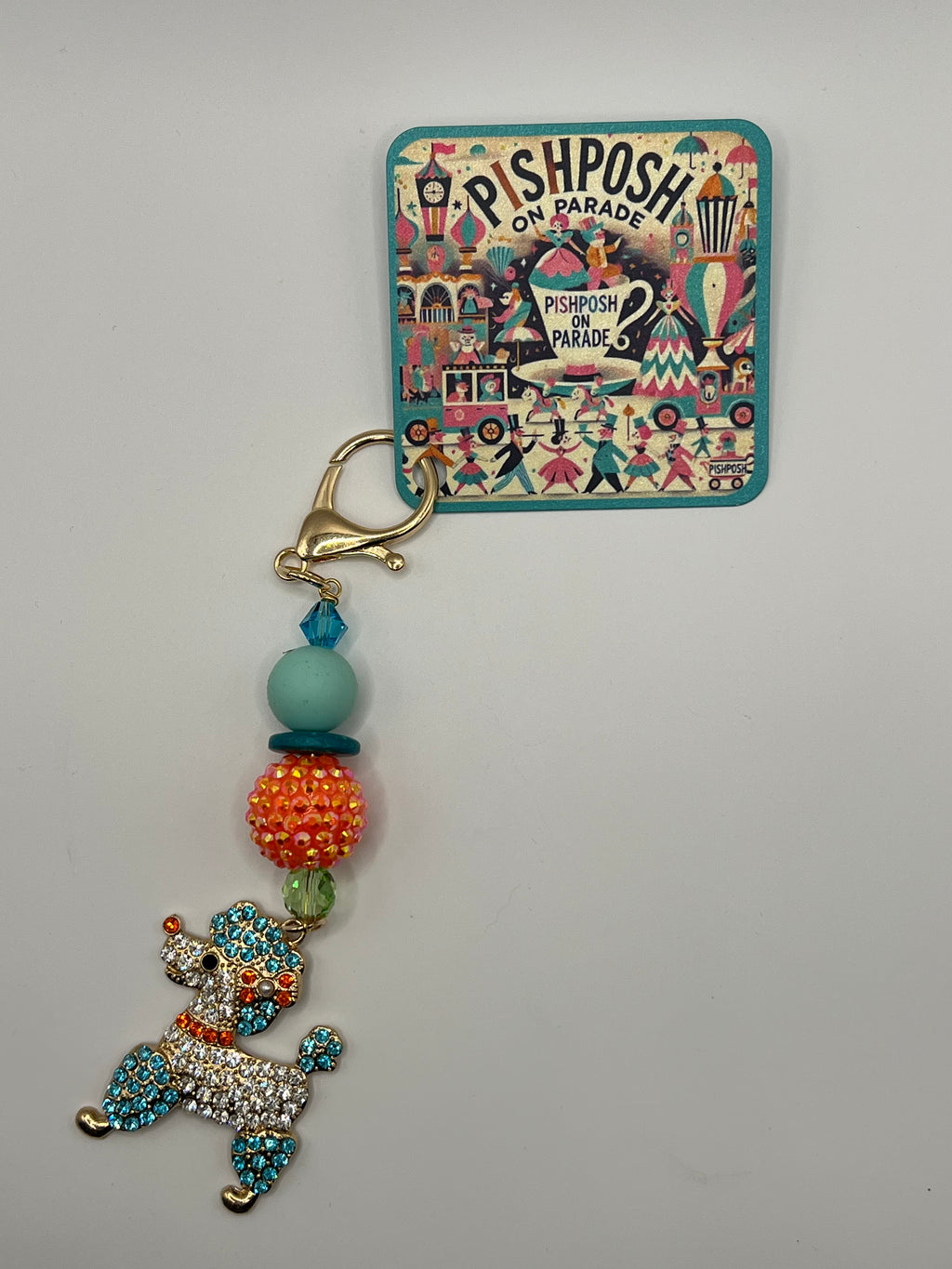 Multi-colored poodle with orange bead charm