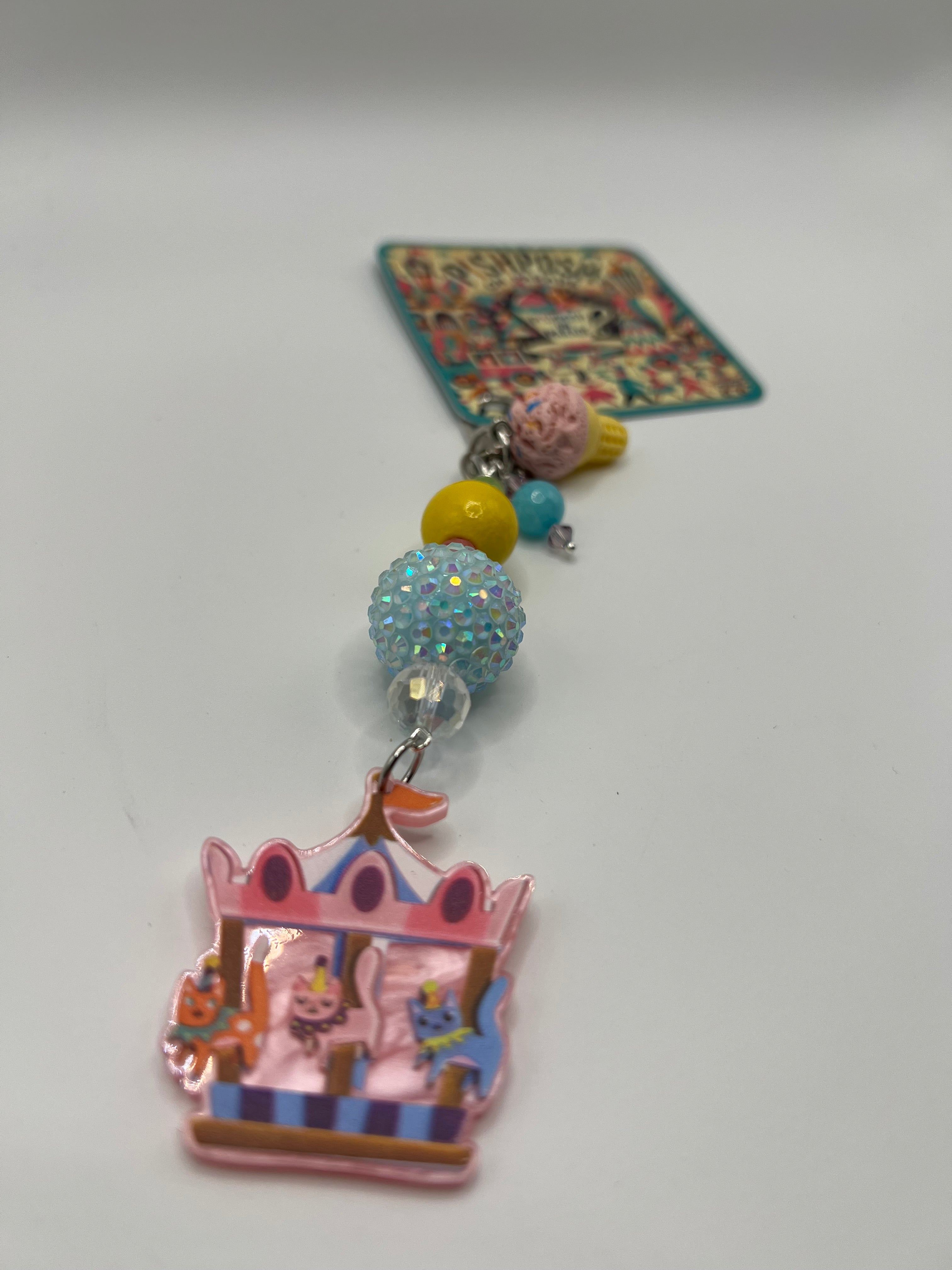 Cats on carousel with pink ice cream charm